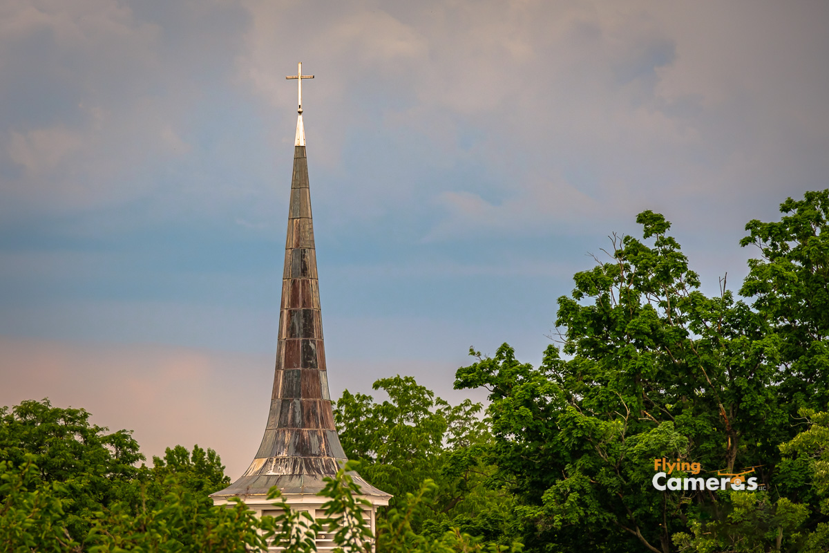 First Baptist Church steeple glowing in emerging sun light after a  storm