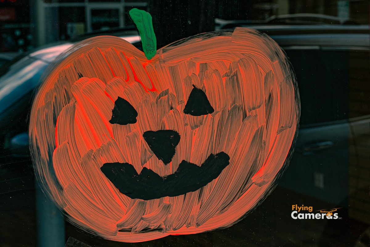 Irridescent orange pumpkin painted on holiday halloween store front window