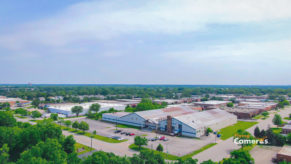 Oblique angle aerial view of a commercial building and parking lot in an industrial park