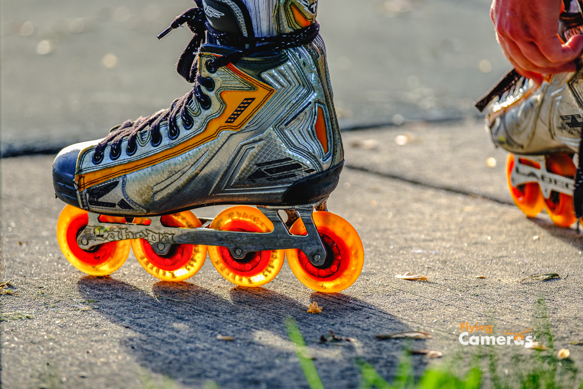 Translucent orange wheels on roller blades glisten in the sun