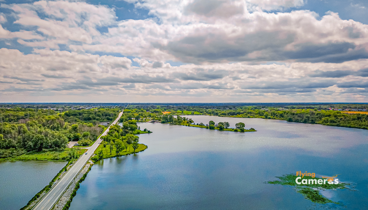 Aerial Image of the blue water of Tampier lake near Orland Park taken at 250 ft elevation with a cloudy and sunny blue sky